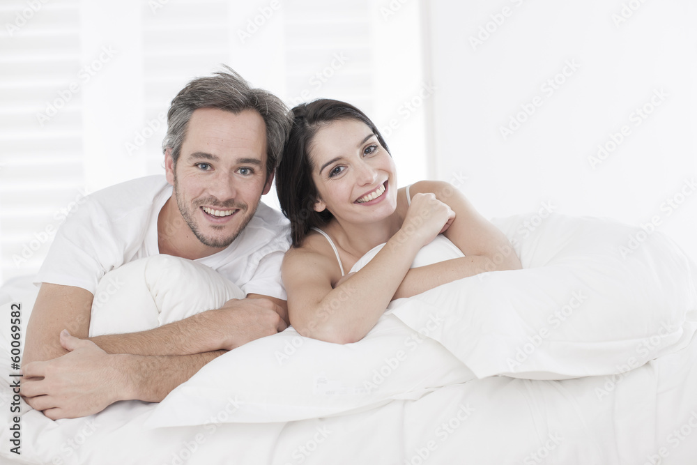 Young couple lying together in bed in the bedroom Young couple lying together in bed in the bedroom