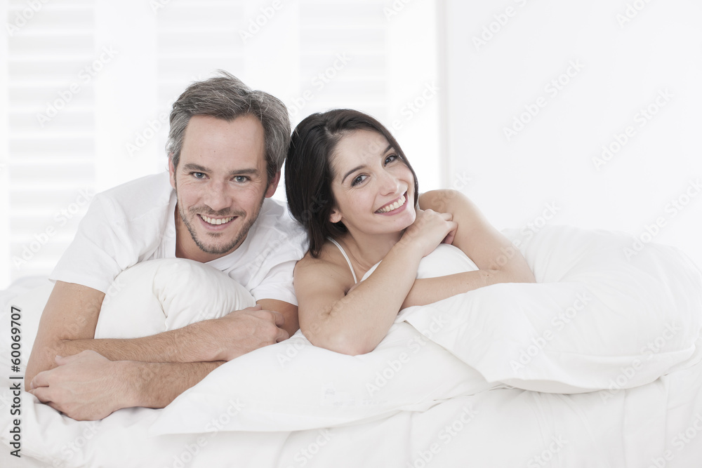 Young couple lying together in bed in the bedroom Young couple lying together in bed in the bedroom
