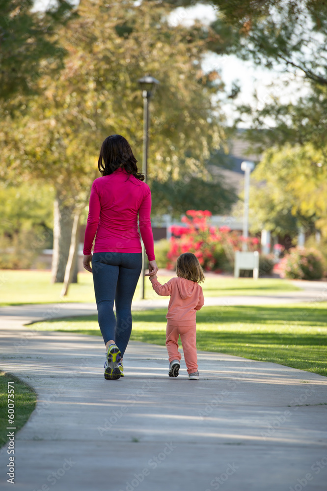 Beautiful mother and daughter walking in the neighborhood