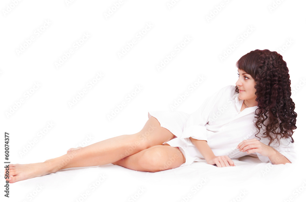 Obraz premium Beautiful young woman in white shirt lying on a bed
