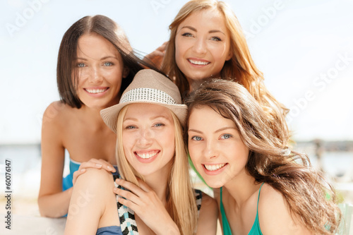 group of smiling girls in cafe on the beach photo