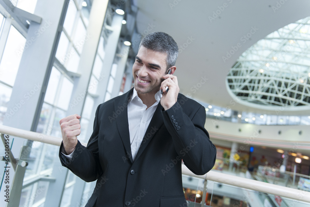 Businessman celebrates talking on mobile phone Businessman celebrates talking on mobile phone