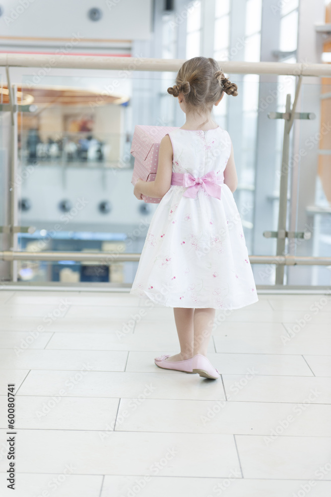 Young girl holding gift wrapped boxes walking away from camera Young girl holding gift wrapped boxes walking away from camera