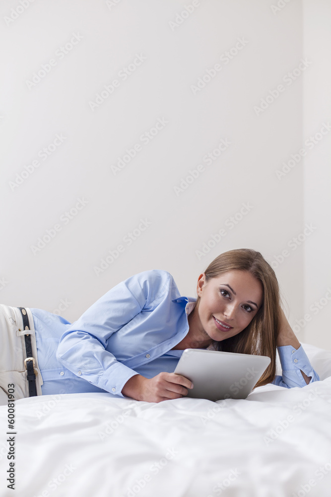 Beautiful woman using tablet computer on her bed Beautiful woman using tablet computer on her bed