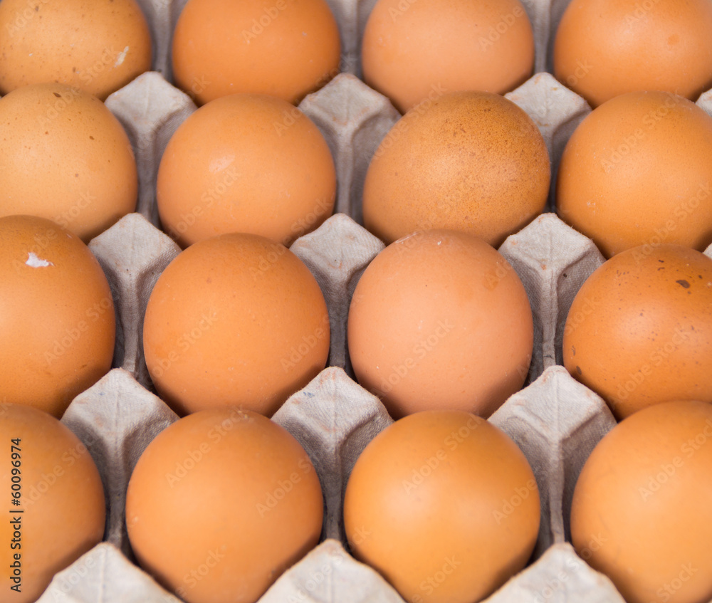 Closeup of many fresh brown eggs in carton tray