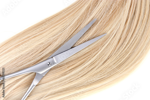 Long blond hair and scissors close up