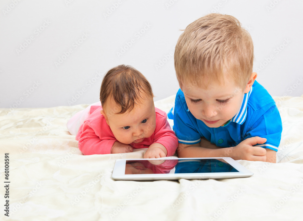 brother and sister with touch pad at home brother and sister with touch pad at home