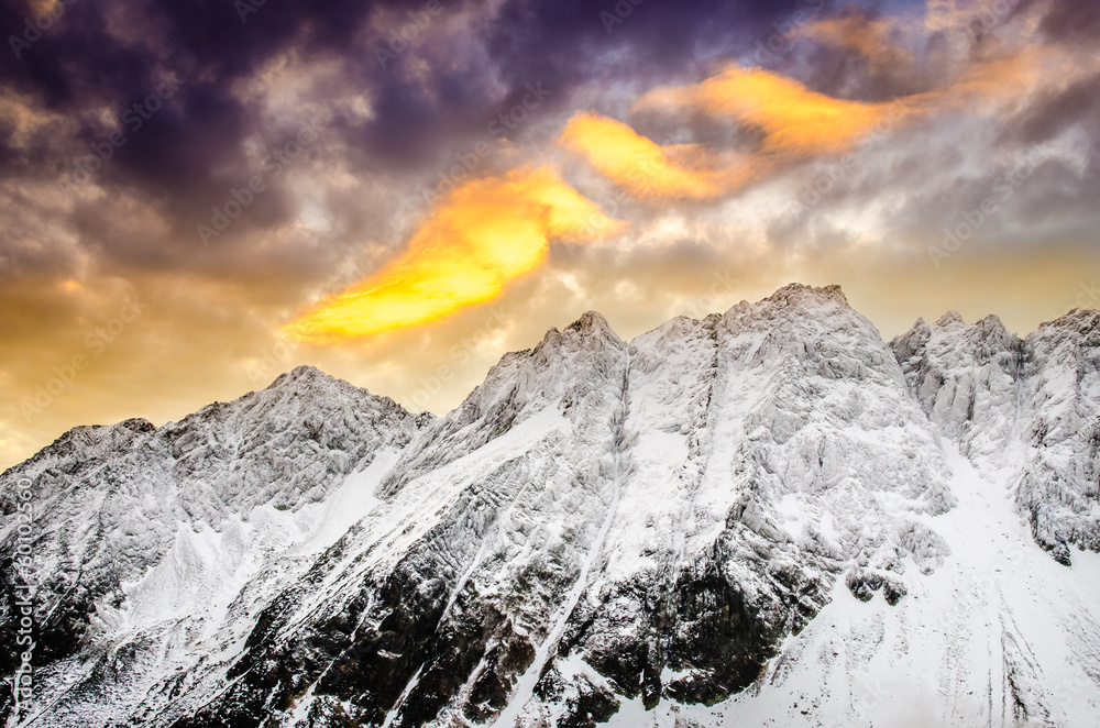 Winter mountains with dramatic colorful sky at sunset
