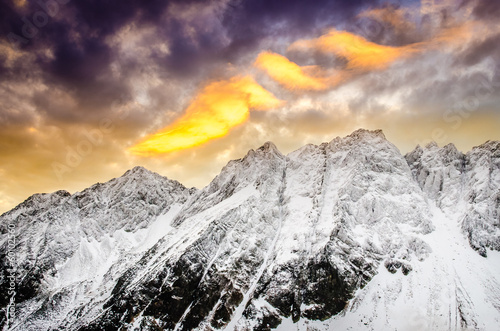 Winter mountains with dramatic colorful sky at sunset