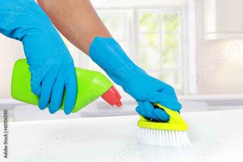 hand with glove using cleaning brush to clean up