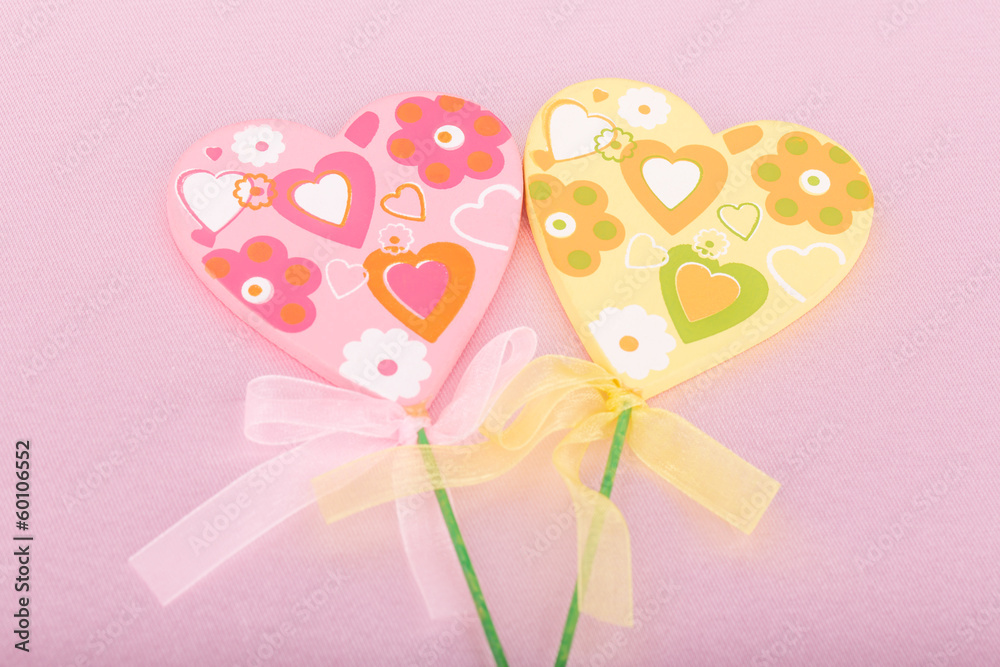 Pink and yellow handmade hearts over pink background