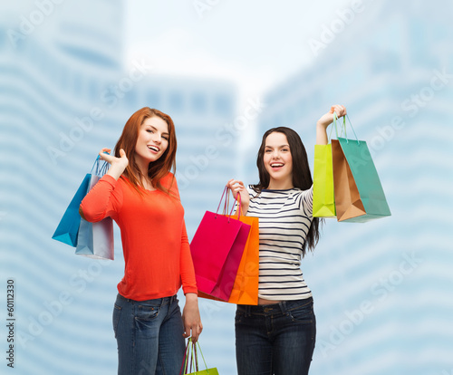 two smiling teenage girls with shopping bags photo