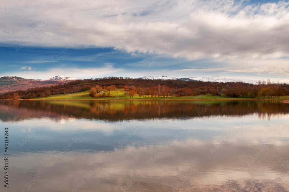 reflection of the mountains and fields in the Garaio reservoir w