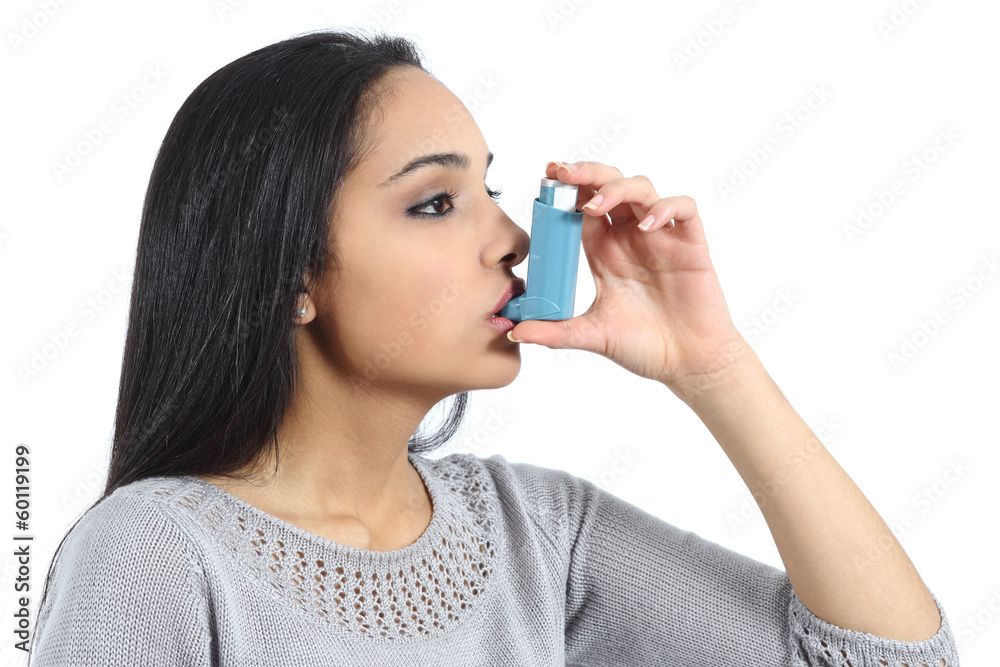 Asthmatic arab woman breathing from a inhaler Asthmatic arab woman breathing from a inhaler
