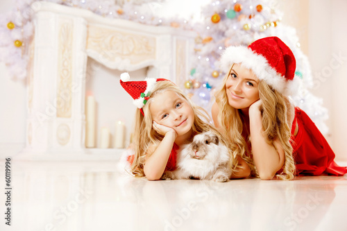 Mom and daughter dressed as Santa celebrate Christmas. Family at