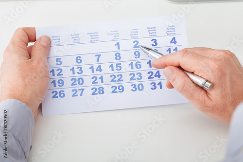 Hand Holding Calendar And Pen