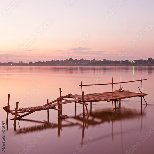 Tranquil sunset with a jetty on Mekong river in autumn.