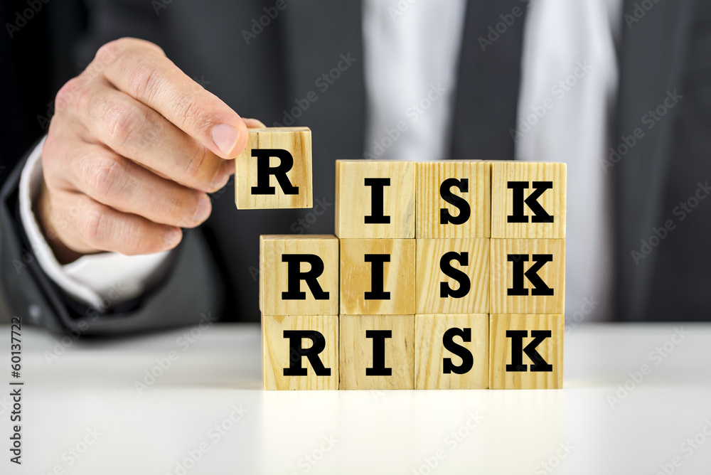 Naklejka premium Man stacking wooden risk blocks