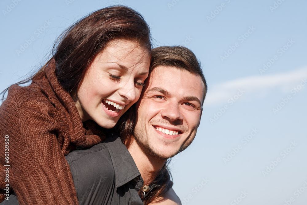 young male giving his girlfriend piggyback ride