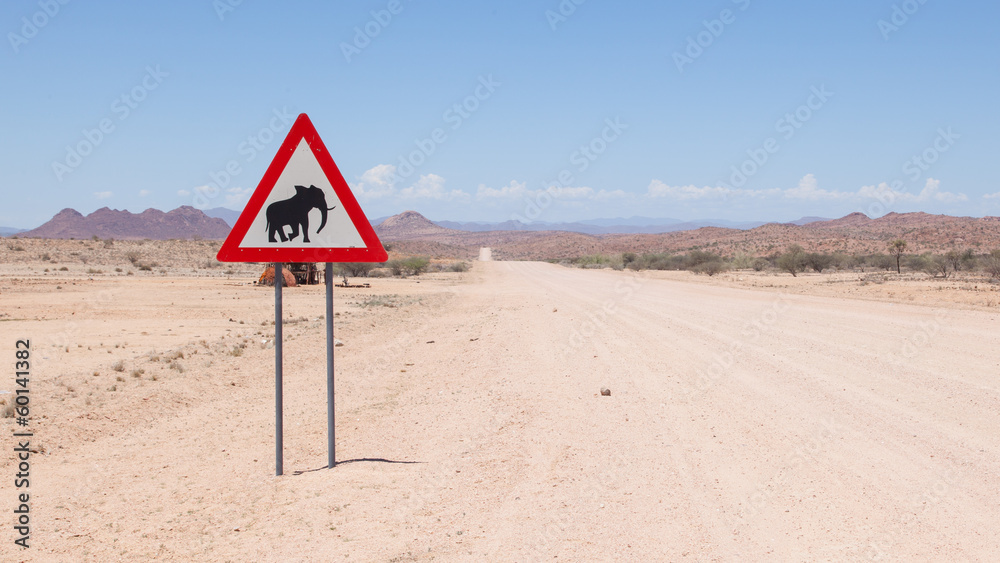 Caution: Elephants! Road sign standing beside road
