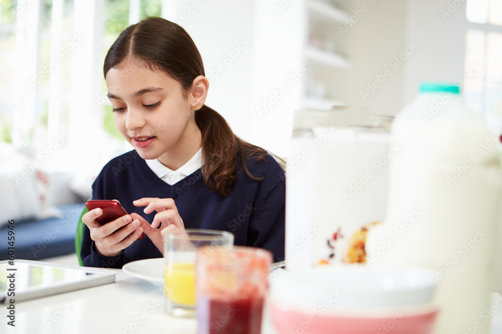 Schoolgirl With Digital Tablet And Mobile At Breakfast Schoolgirl With Digital Tablet And Mobile At Breakfast