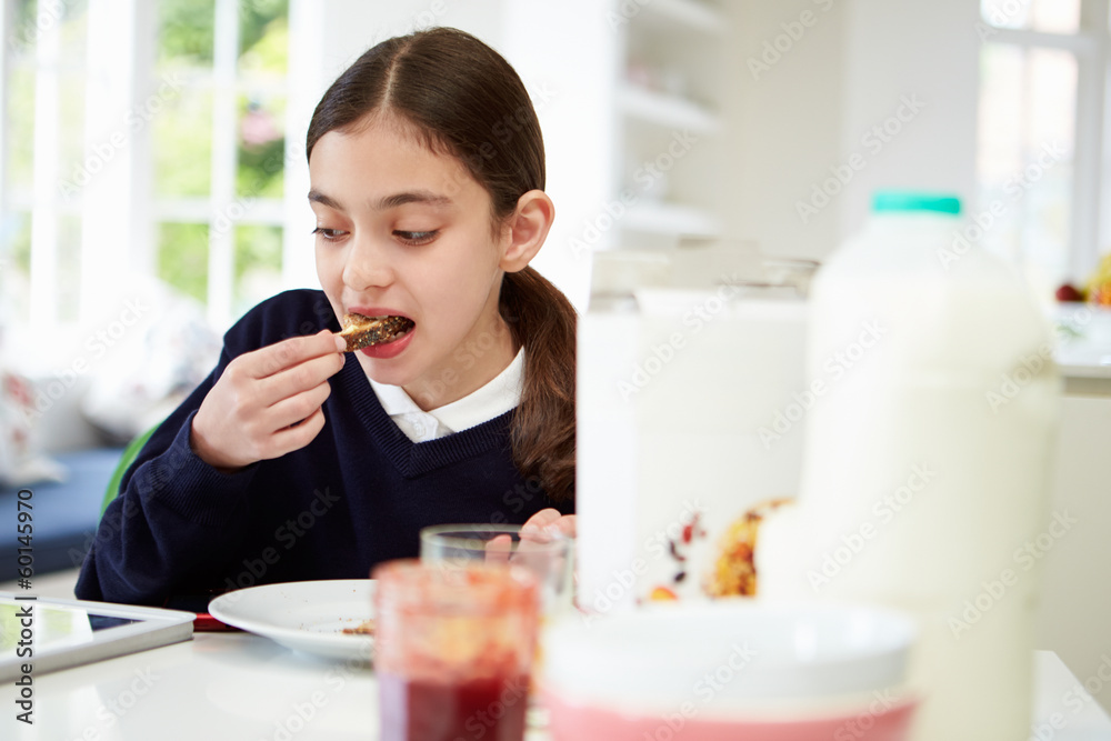 Schoolgirl With Digital Tablet And Mobile Eating Toast