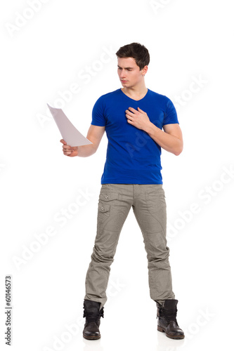 Tableau sur toile Handsome young man reading document.