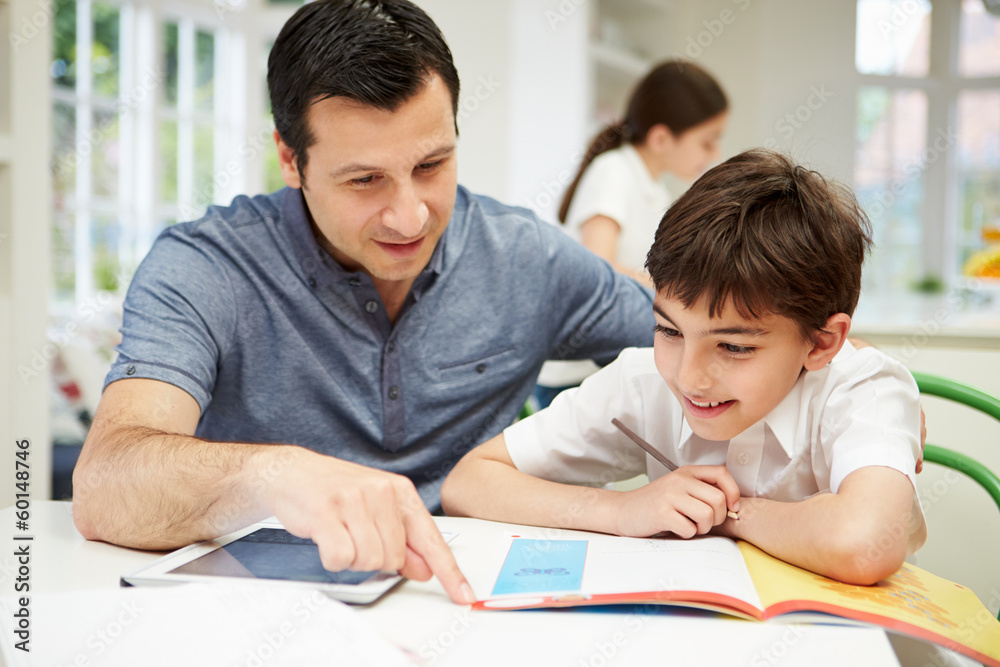 Father Helping Son With Homework Using Digital Tablet Father Helping Son With Homework Using Digital Tablet