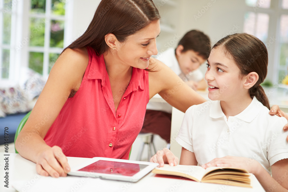 Mother Helping Daughter With Homework Using Digital Tablet Mother Helping Daughter With Homework Using Digital Tablet
