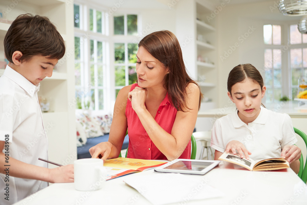Mother Helping Children With Homework Using Digital Tablet Mother Helping Children With Homework Using Digital Tablet