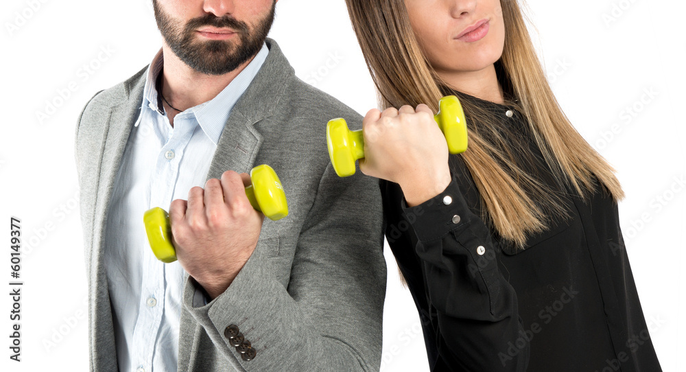 Young couple doing weightlifting over white background Young couple doing weightlifting over white background