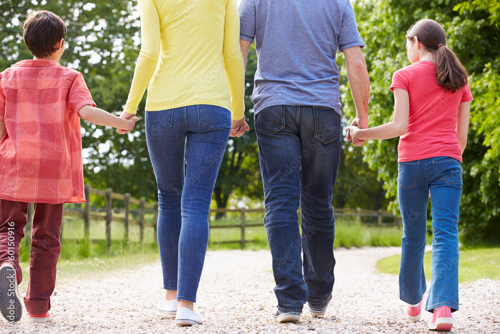 Fototapeta premium Rear View Of Hispanic Family Walking In Countryside