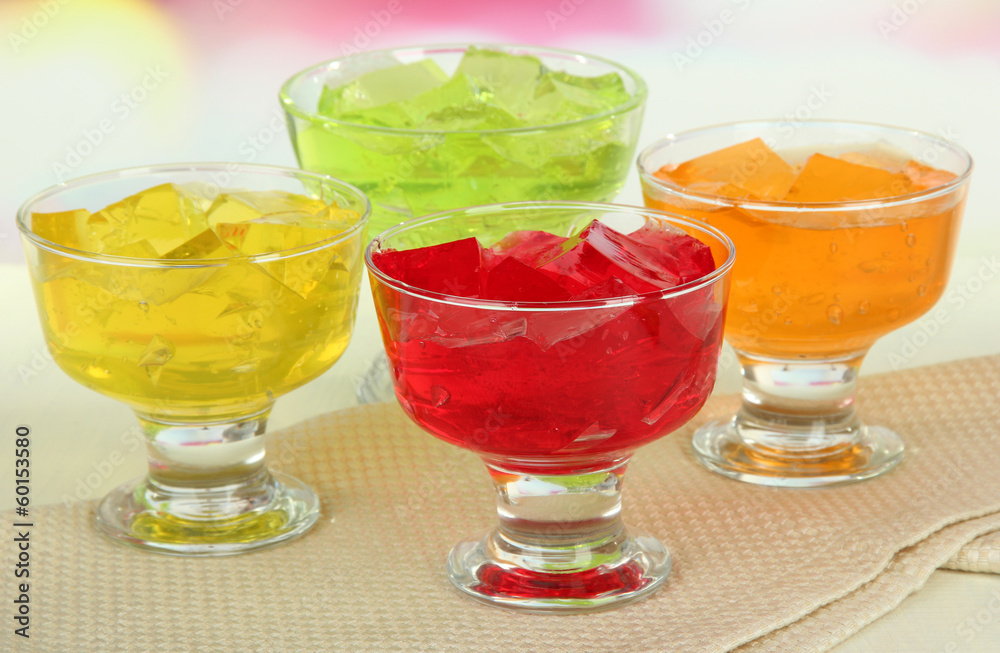 Tasty jelly cubes in bowls on table on light background