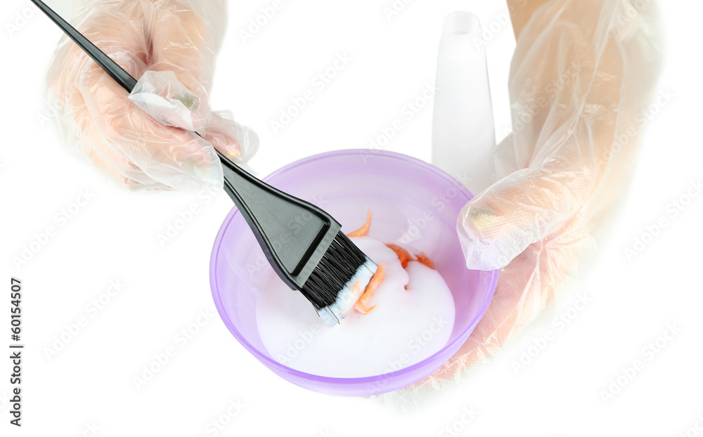 Naklejka premium Female hand in gloves dips with brush for hair coloring,