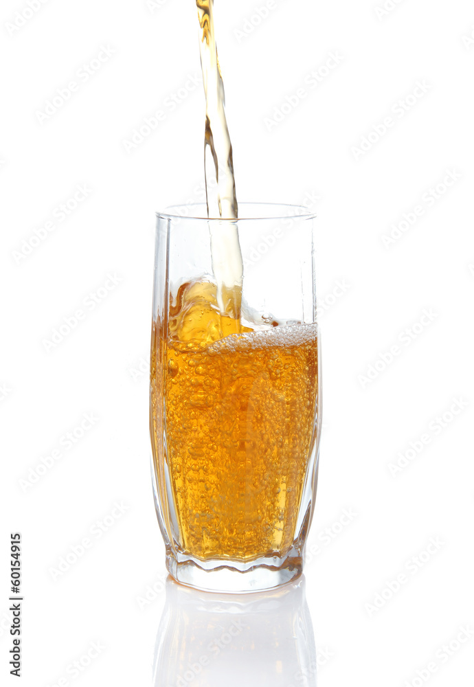Juice pouring into glass isolated on white