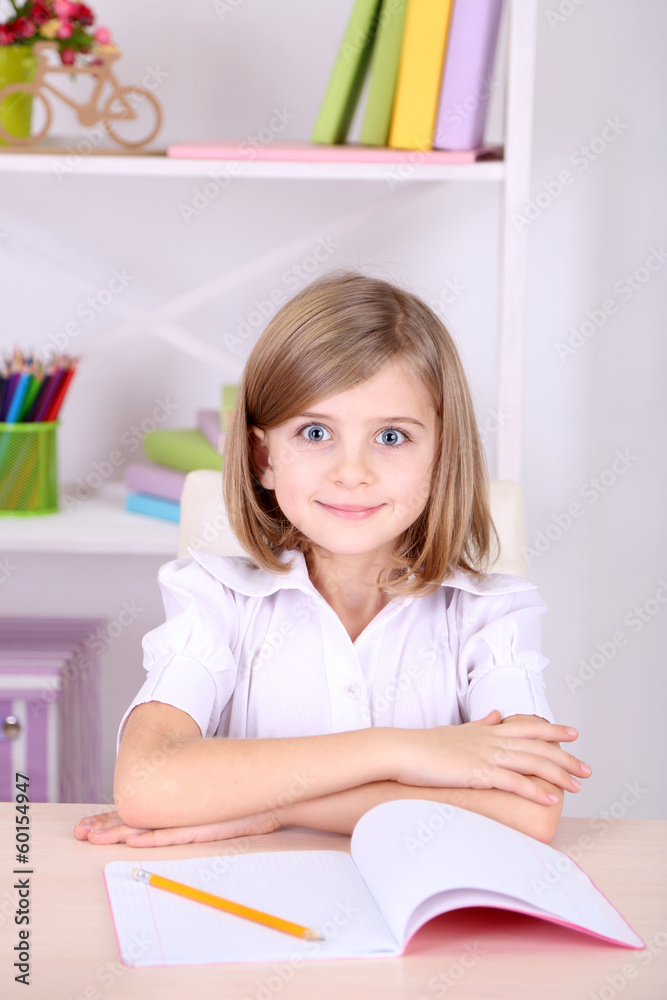 Little girl sitting at desk in room Little girl sitting at desk in room