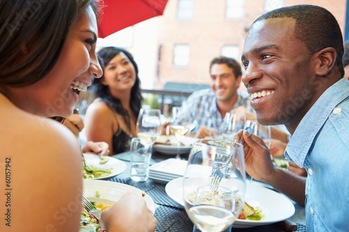 Group Of Friends Enjoying Meal At Outdoor Restaurant