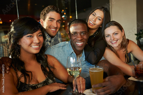 Group Of Friends Enjoying Drink At Bar Together