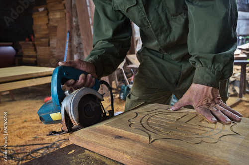 man cutting wood by machine