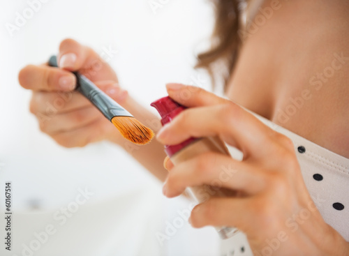 Closeup on young woman using makeup
