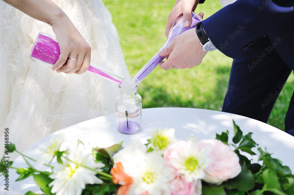 bride and groom doing sand ceremony during wedding bride and groom doing sand ceremony during wedding