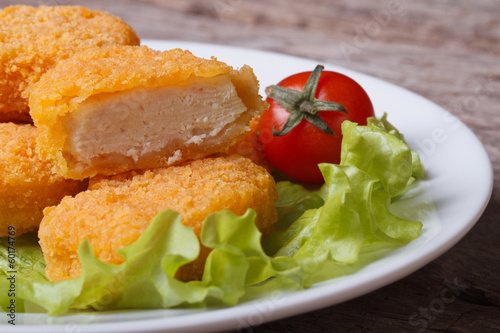 Sliced ​​chicken nuggets, salad and cherry tomatoes