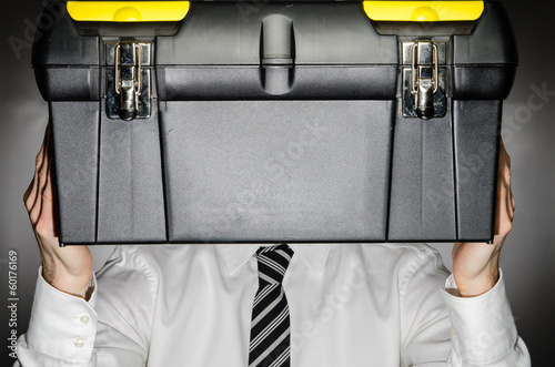 Canvas Print Man wearing tie holding toolbox in front of face