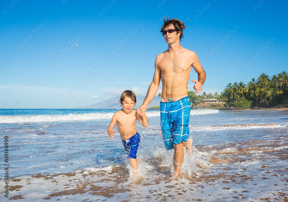 Happy father and son walking together at beach