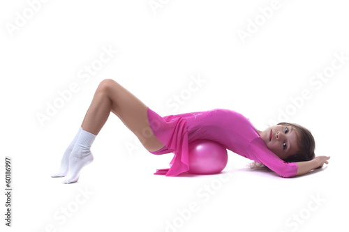 Cute little gymnast posing lying in studio