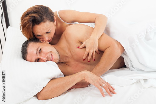 Adult lovers kissing in bed