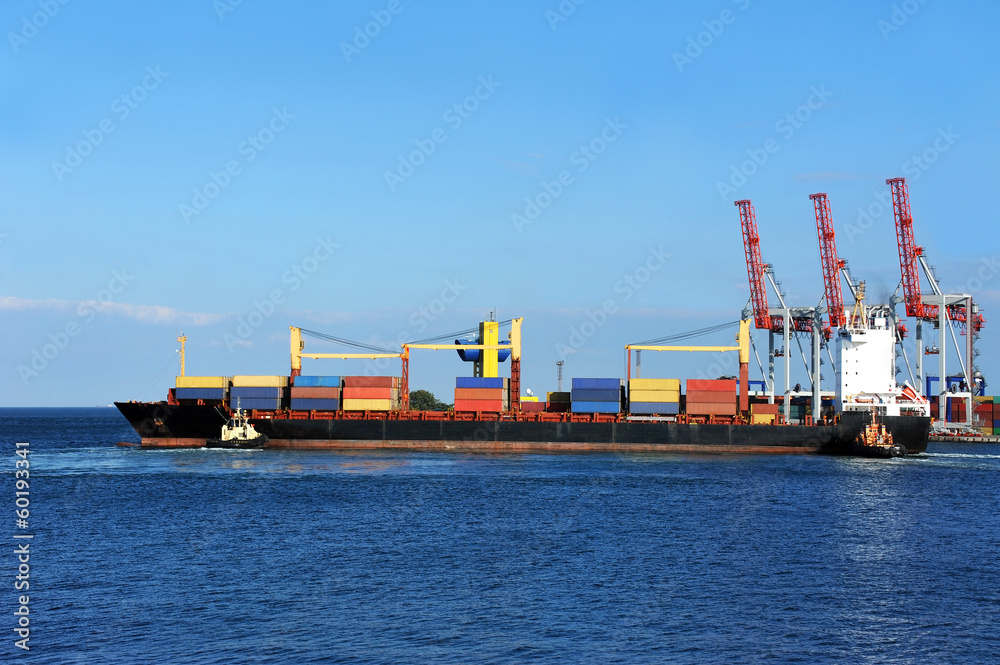 Tugboat assisting container cargo ship to harbor quayside Tugboat assisting container cargo ship to harbor quayside