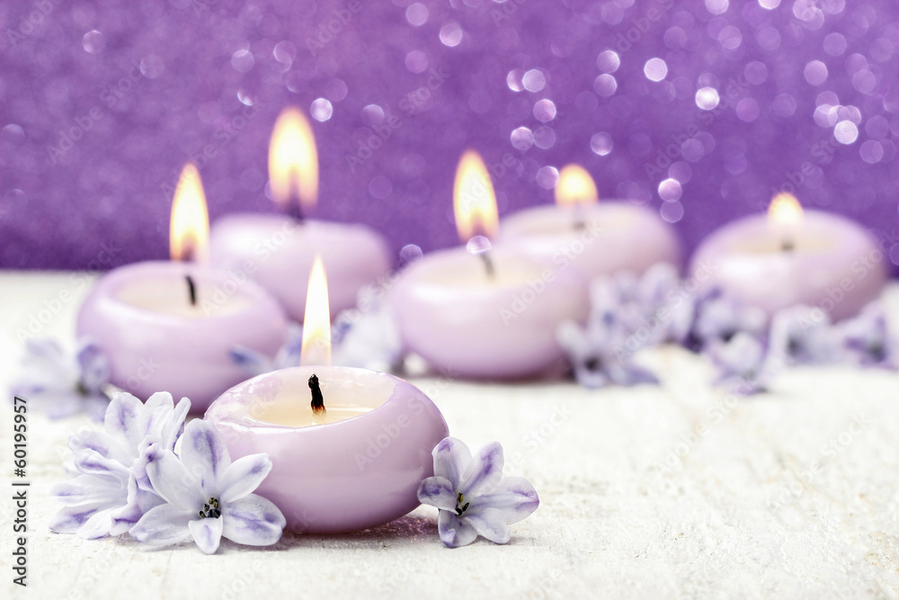 Scented candles and hyacinth flowers on violet background Scented candles and hyacinth flowers on violet background