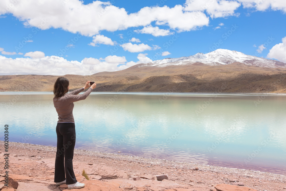 Woman taking pictures of lagoon Celeste, Bolivia