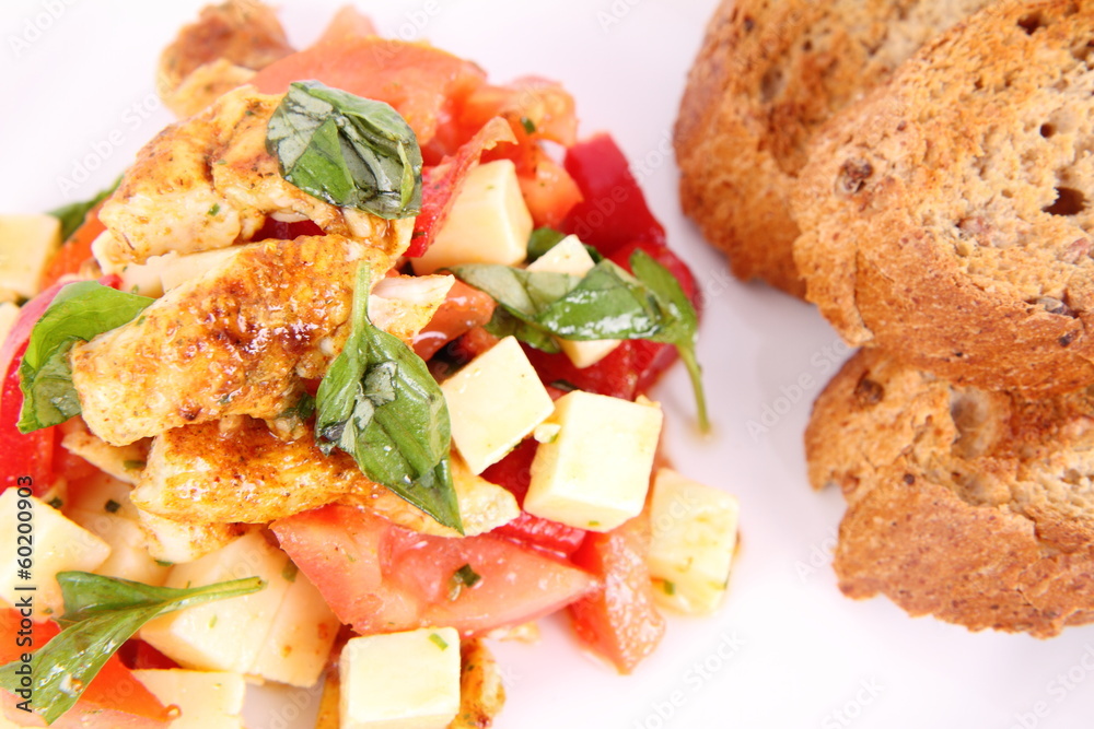 Chicken, cheese & vegetable salad with some bread on a plat Chicken, cheese & vegetable salad with some bread on a plat
